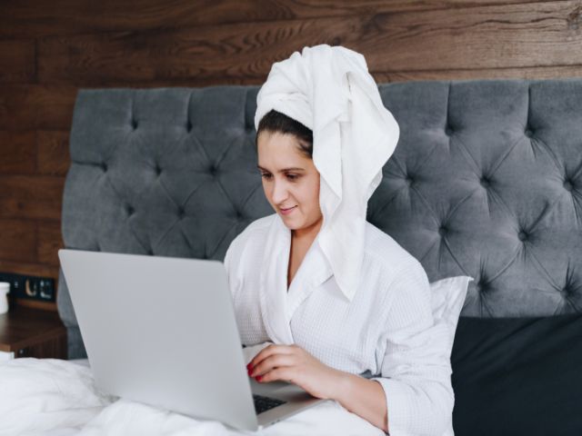 頭にタオルを巻いてパソコンを操作する女性