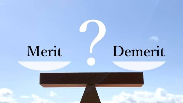 秤に乗せられた「Merit」と「Demerit」の文字」